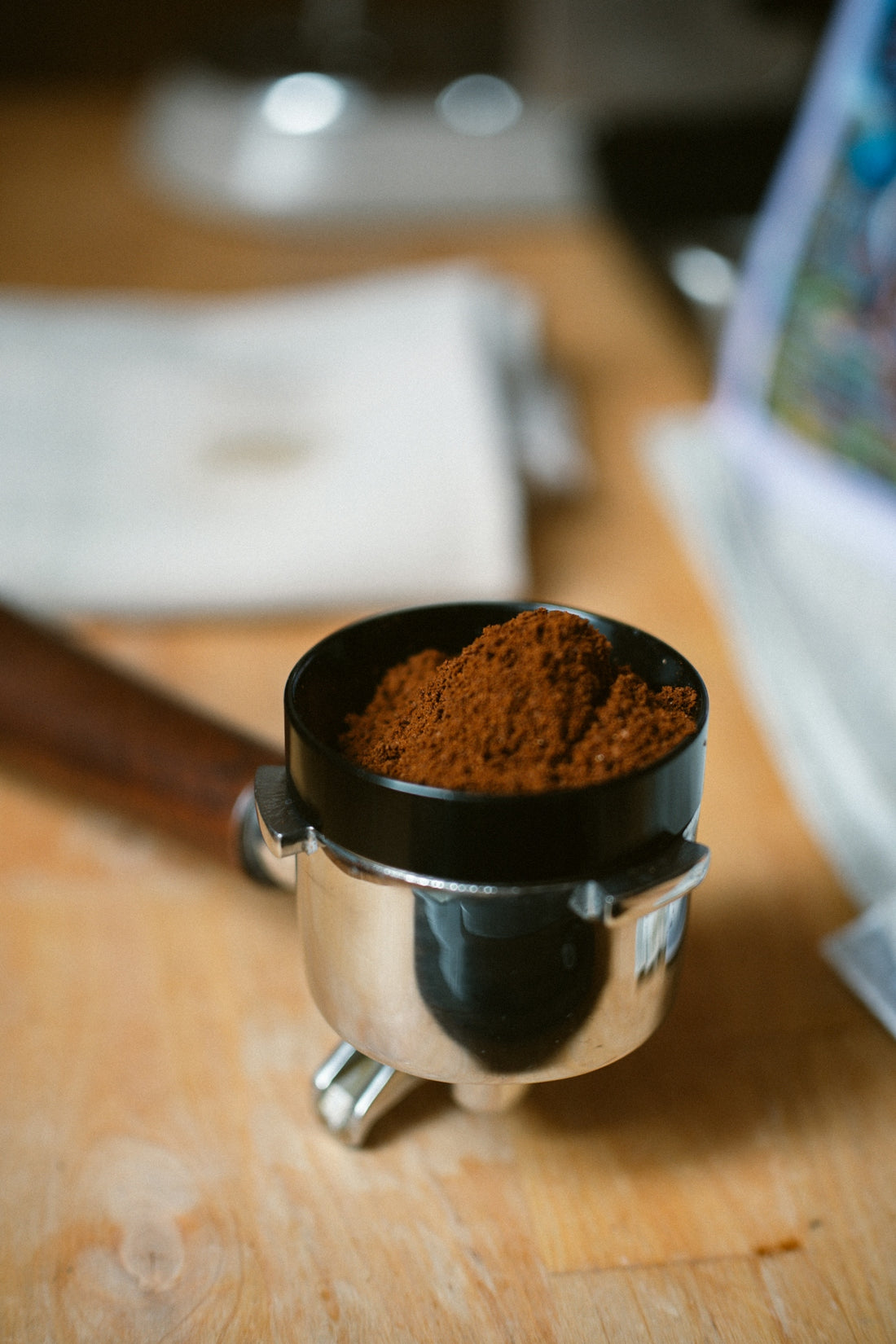 A wooden table topped with a metal cup filled with coffee